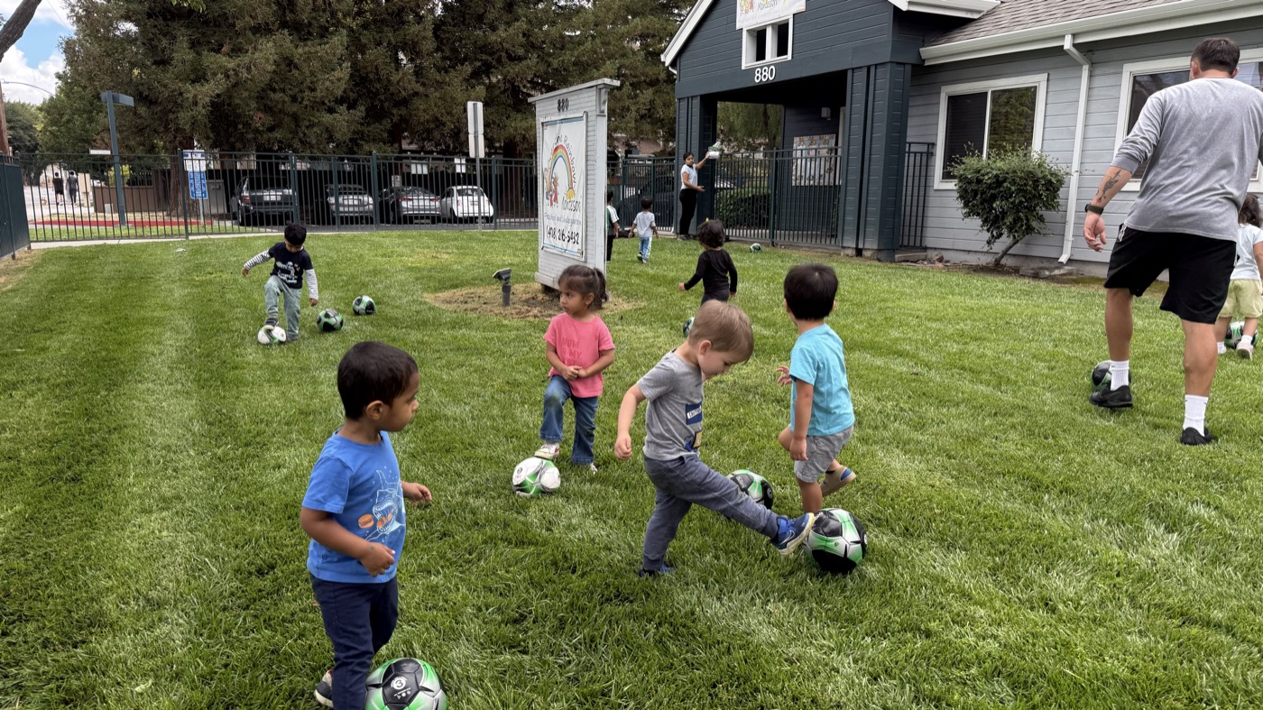 Children playing soccer outside Over the Rainbow Montessori in San Jose